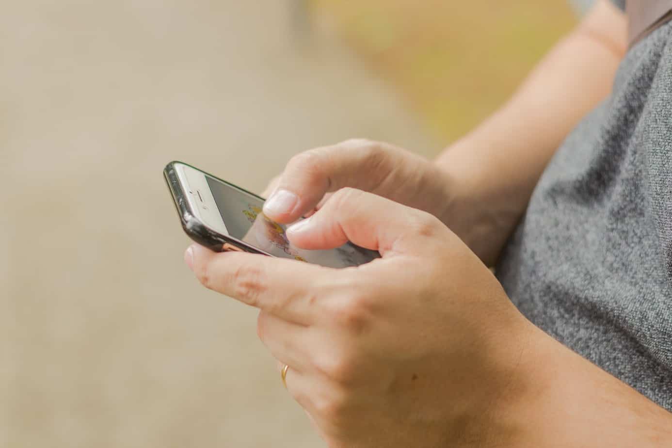 close up photo of mans hands using smartphone