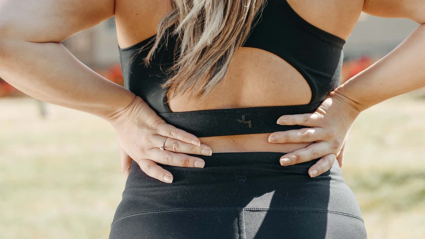 a woman wearing black active wear holding her waist